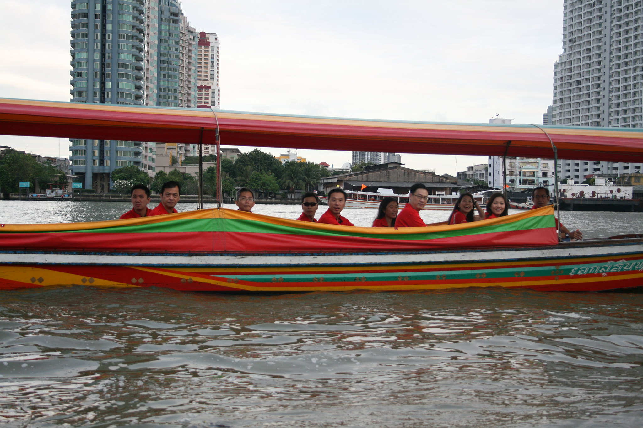 Group enjoying a colorful long-tail boat ride during a Bangkok river cruise.