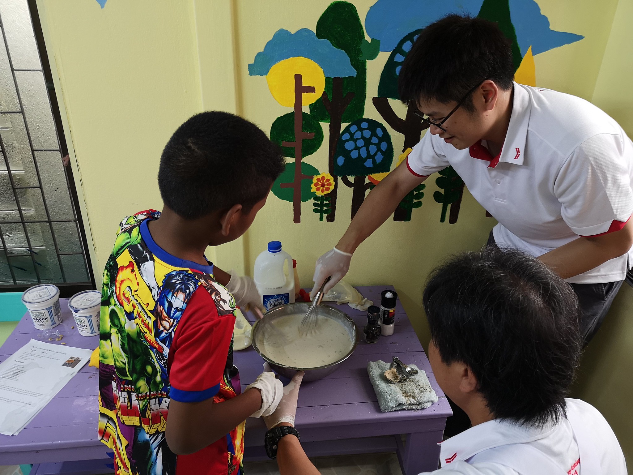 Cooking and Sharing with the Children Corporate volunteers cooking and sharing food with local children during a CSR event in Thailand