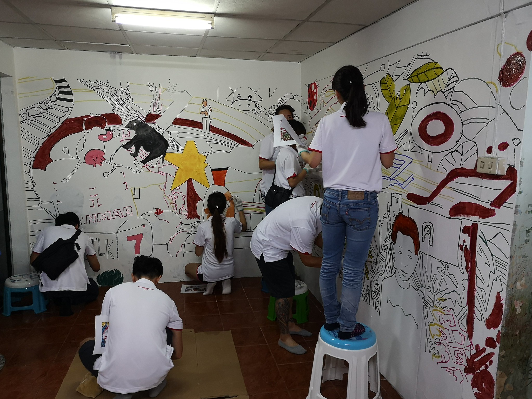 Creative Expression Through Art Team building through art and creativity: employees painting a community mural in Bangkok