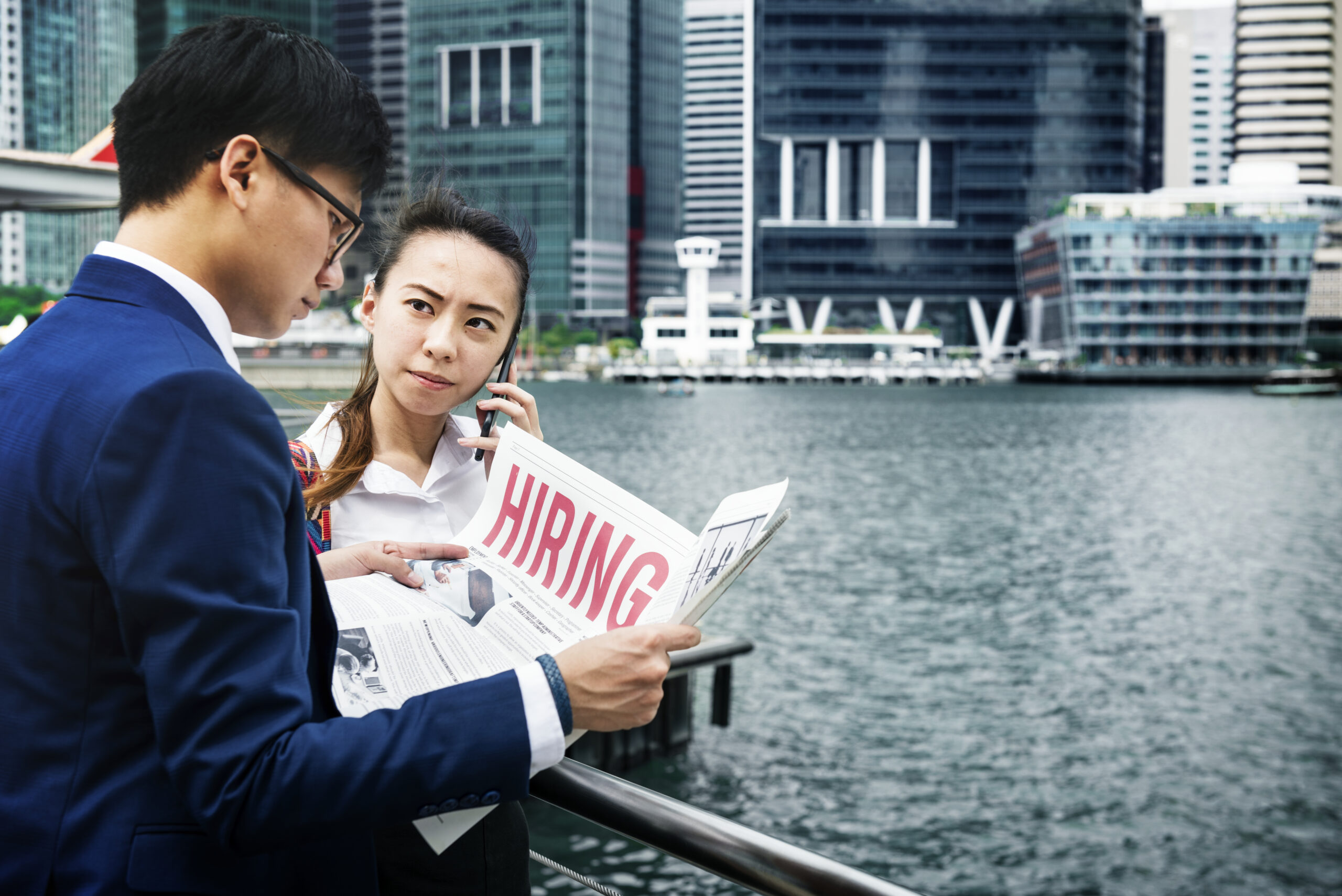 Asian business people in a city working together Business professionals discussing documents by the river, highlighting local expertise and cultural integration in Bangkok.