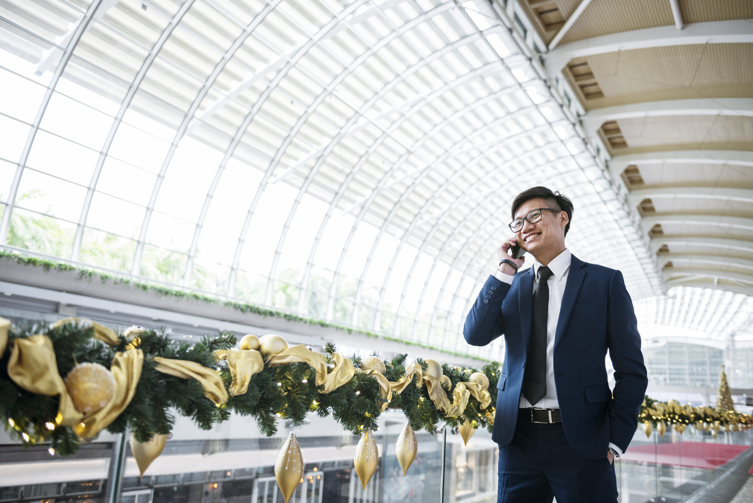 Asian businessman on the phone Event management team reviewing documents together in a covered walkway, coordinating logistics and operations.