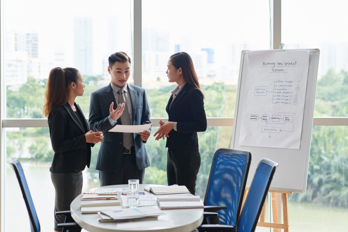 Corporate team discussing strategy and event planning in a bright conference space overlooking the city in Kuala Lumpur.