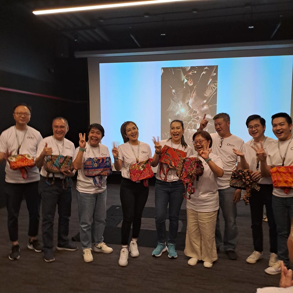 Reflection Through Art and Group Dialogue Corporate team members holding completed art pieces during a reflection session and group dialogue workshop.