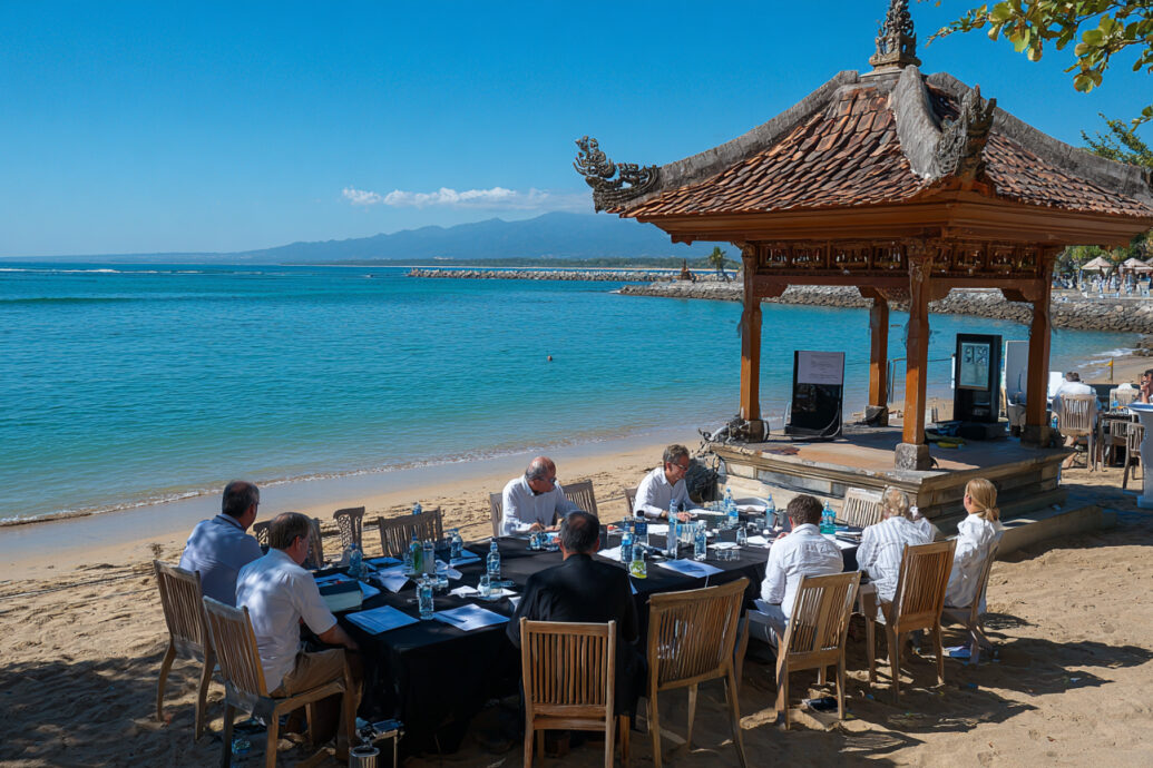 Executive team meeting at a beachfront pavilion in Bali, establishing strategic foundations for exhibition management.