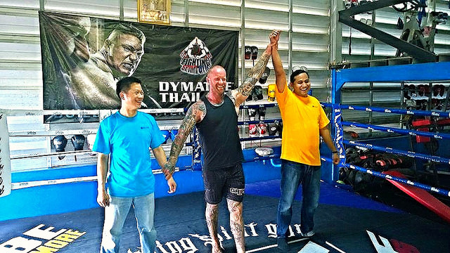 Strategic Urban Team Building in Bangkok Corporate team participating in an urban Muay Thai adventure challenge in Bangkok, posing together at a historic temple site.