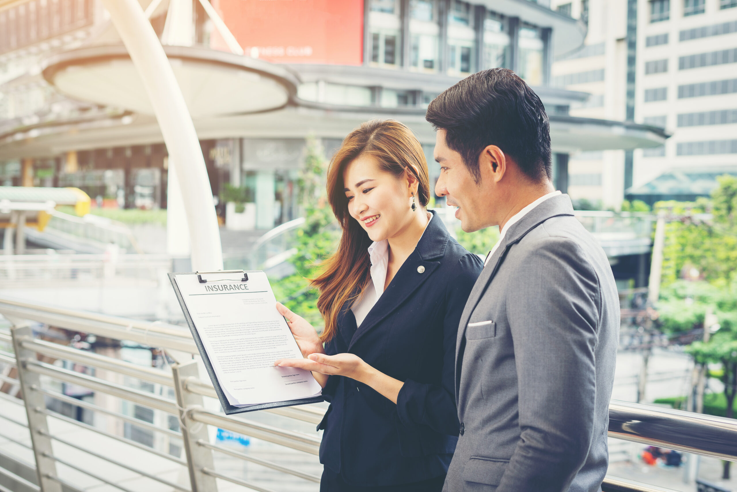 Business man pointing at document with smile and discussing some Business professionals reviewing venue options and strategic positioning plans in an urban setting in Thailand.