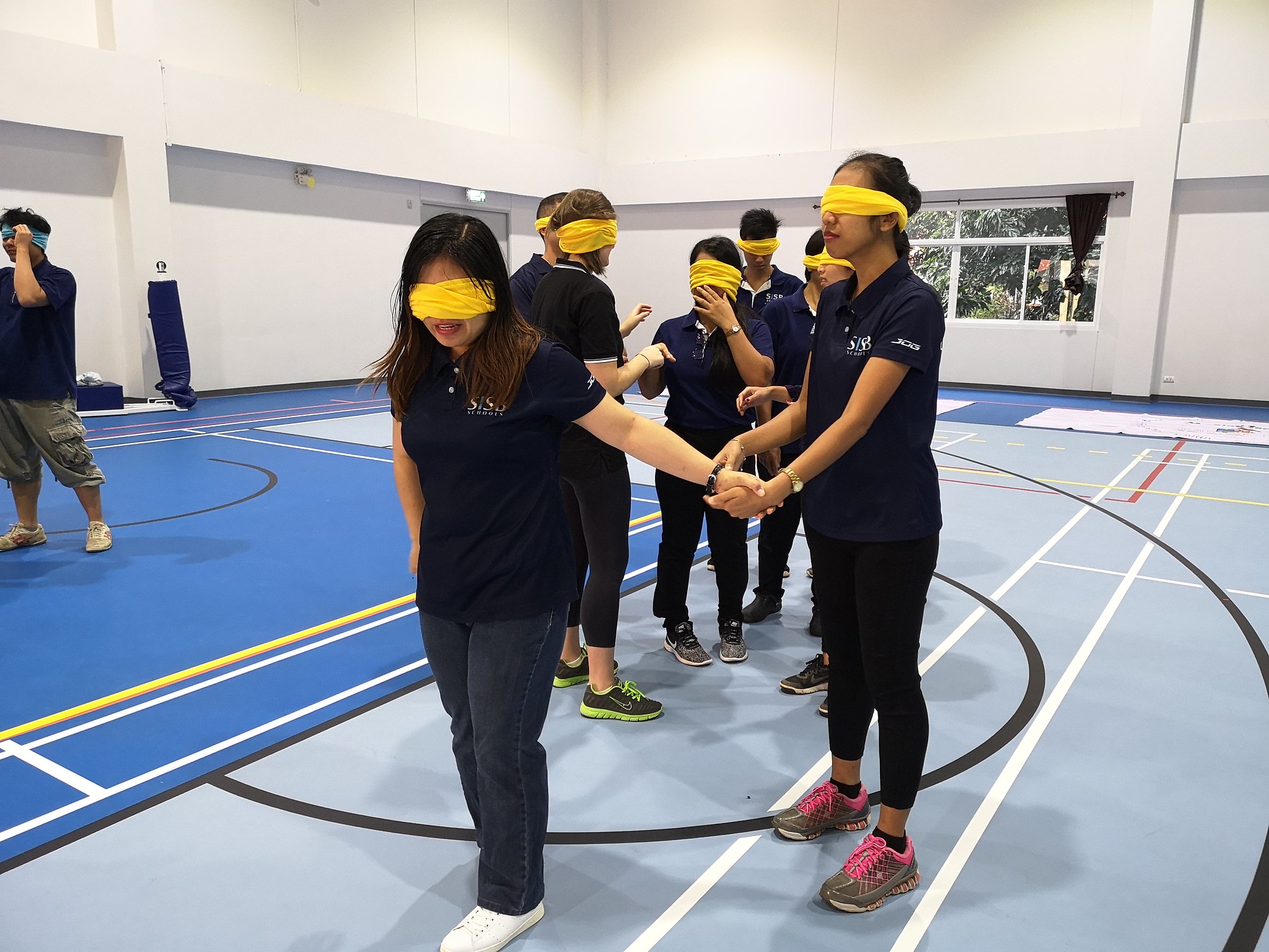 Cross-Functional Collaboration Challenges Team members collaborating to build a cup tower during a corporate indoor team-building exercise in Phuket.
