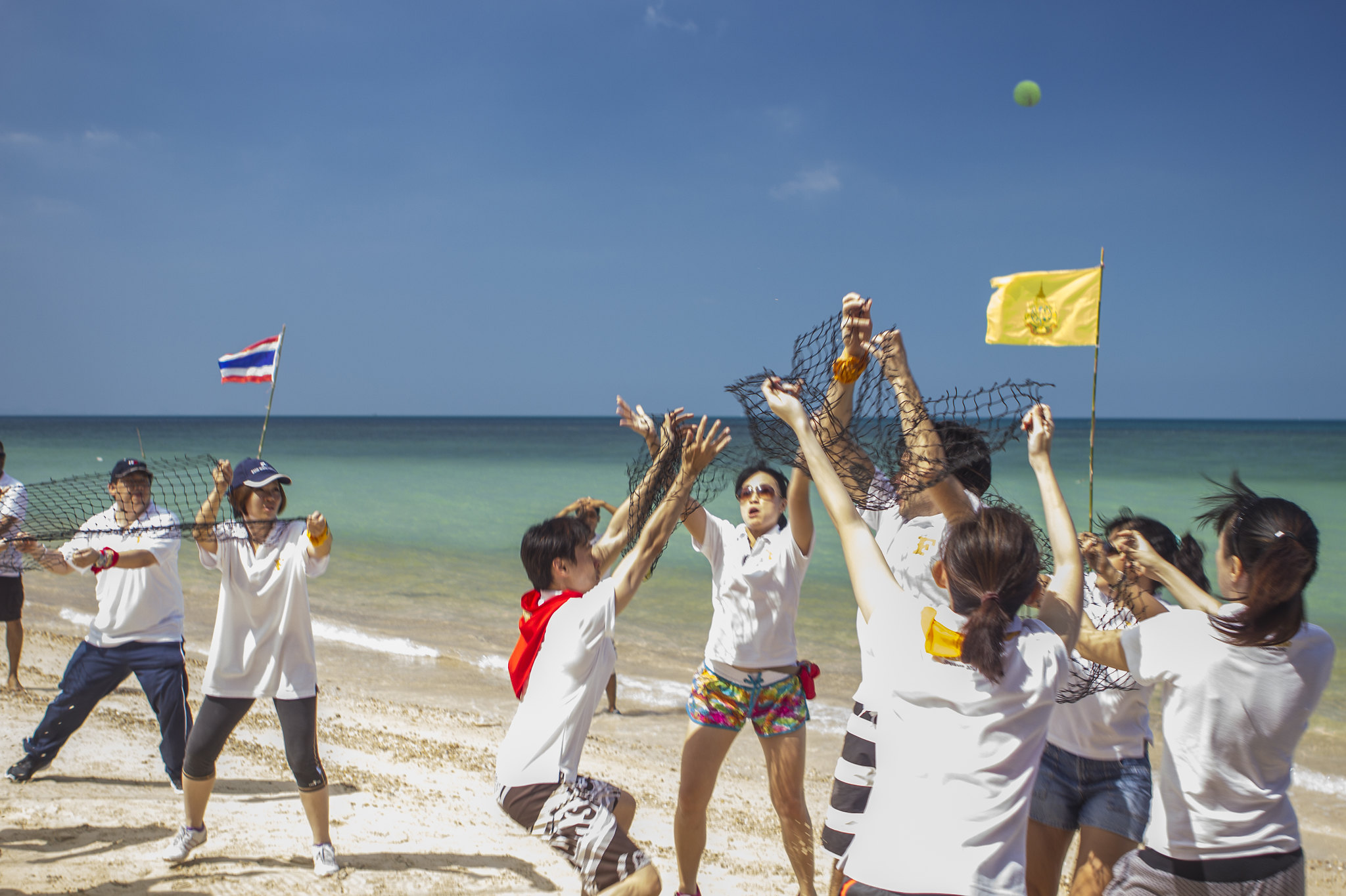 Why Phuket is the Ideal Destination for Survival Team Building Corporate team celebrating successful survival challenge on a Phuket beach