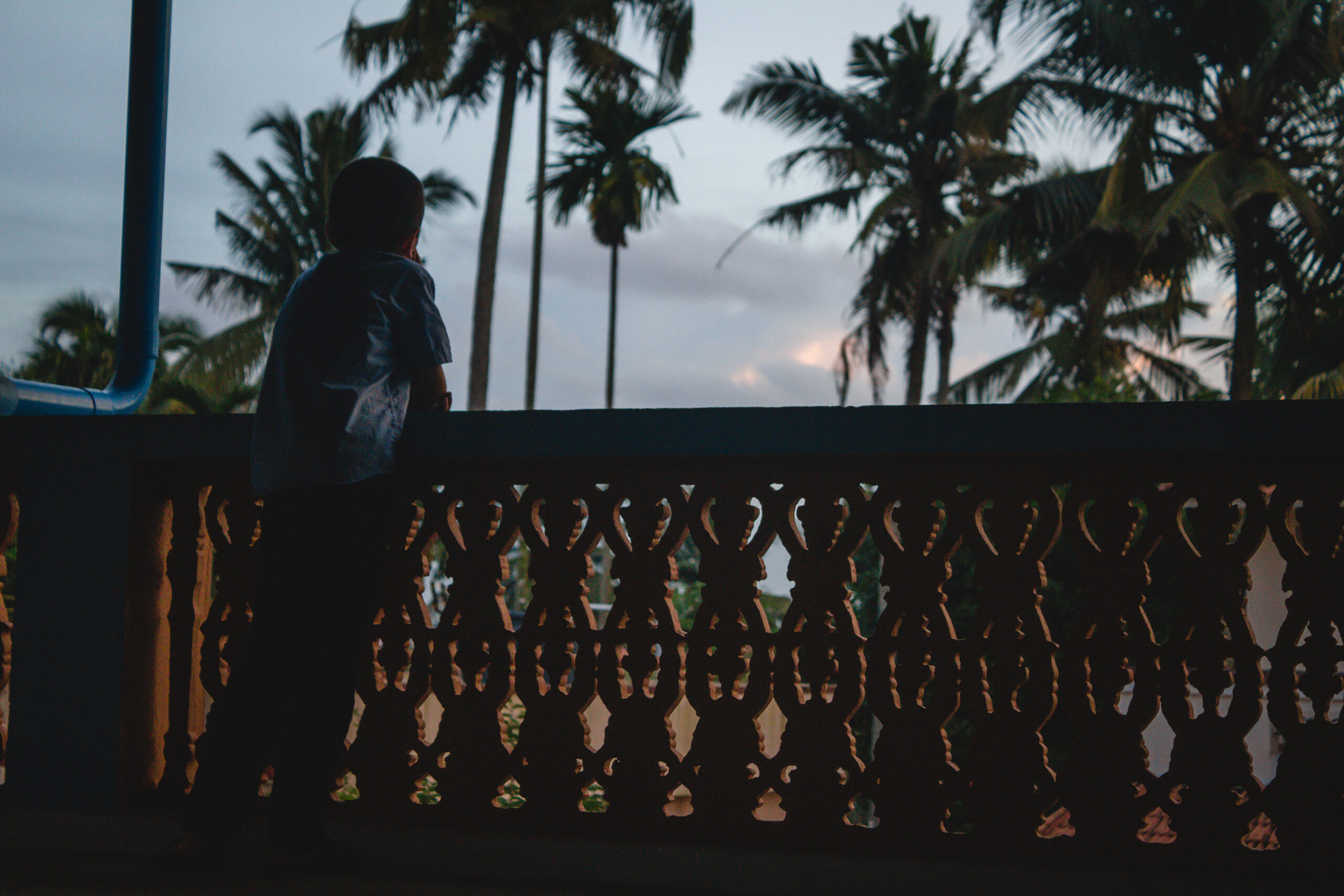 Little Boy standing at a balcony looking out thinking End to end event coordination ensuring seamless execution in destination events