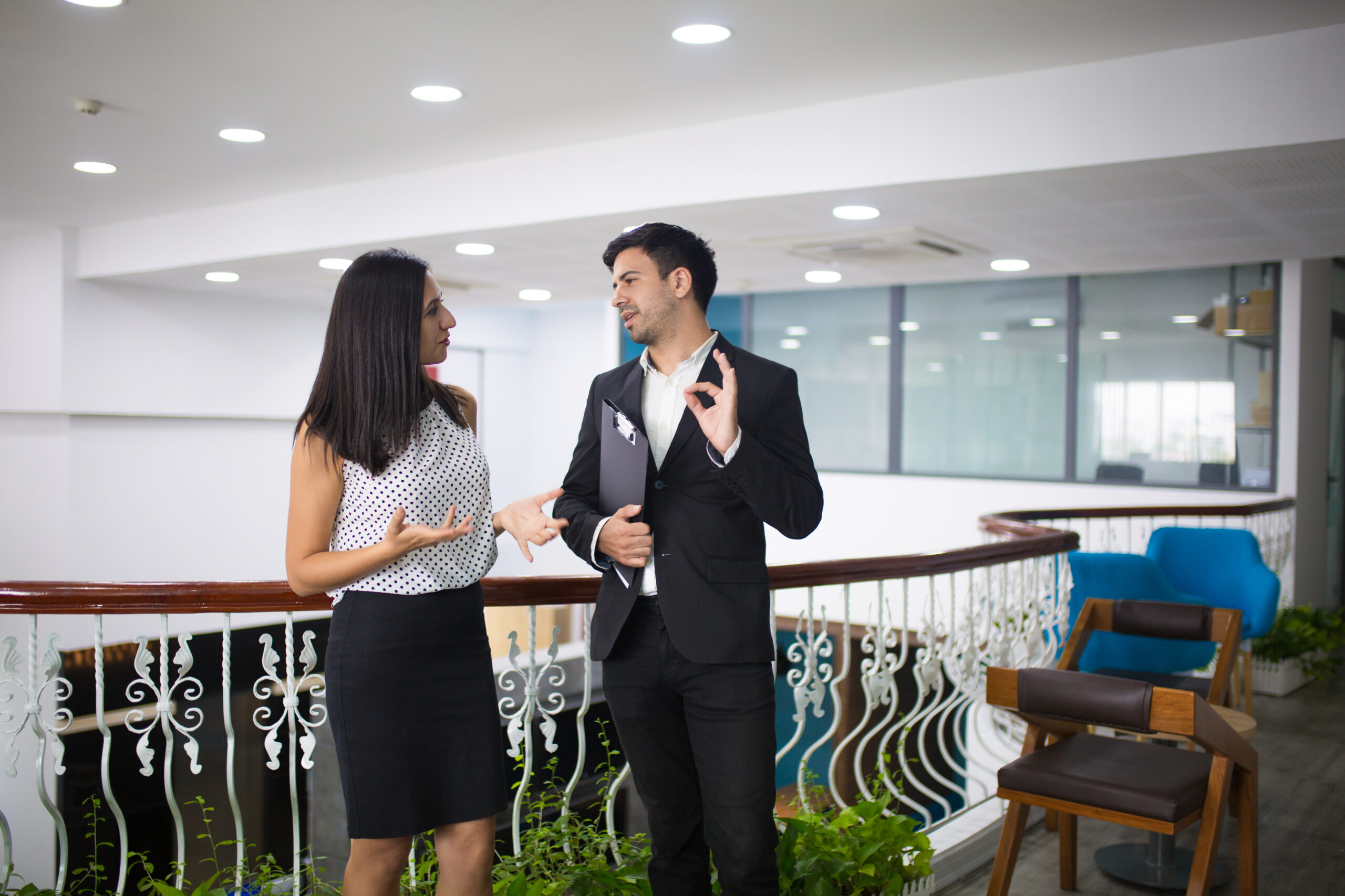 Portrait of happy young colleagues or partners talking in hall Event planning services and partner selection for corporate teams