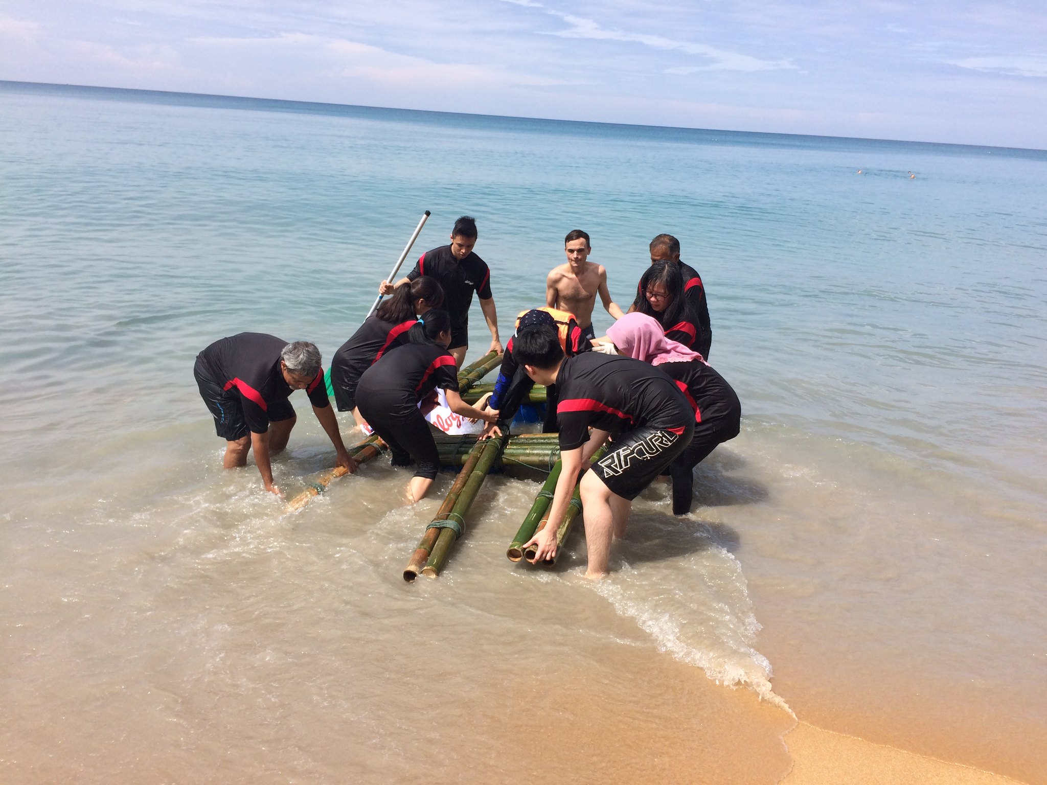Clear Roles Turn Individual Effort into Collective Progress Team members launching their bamboo raft into the sea through clear roles, teamwork, and collective problem solving