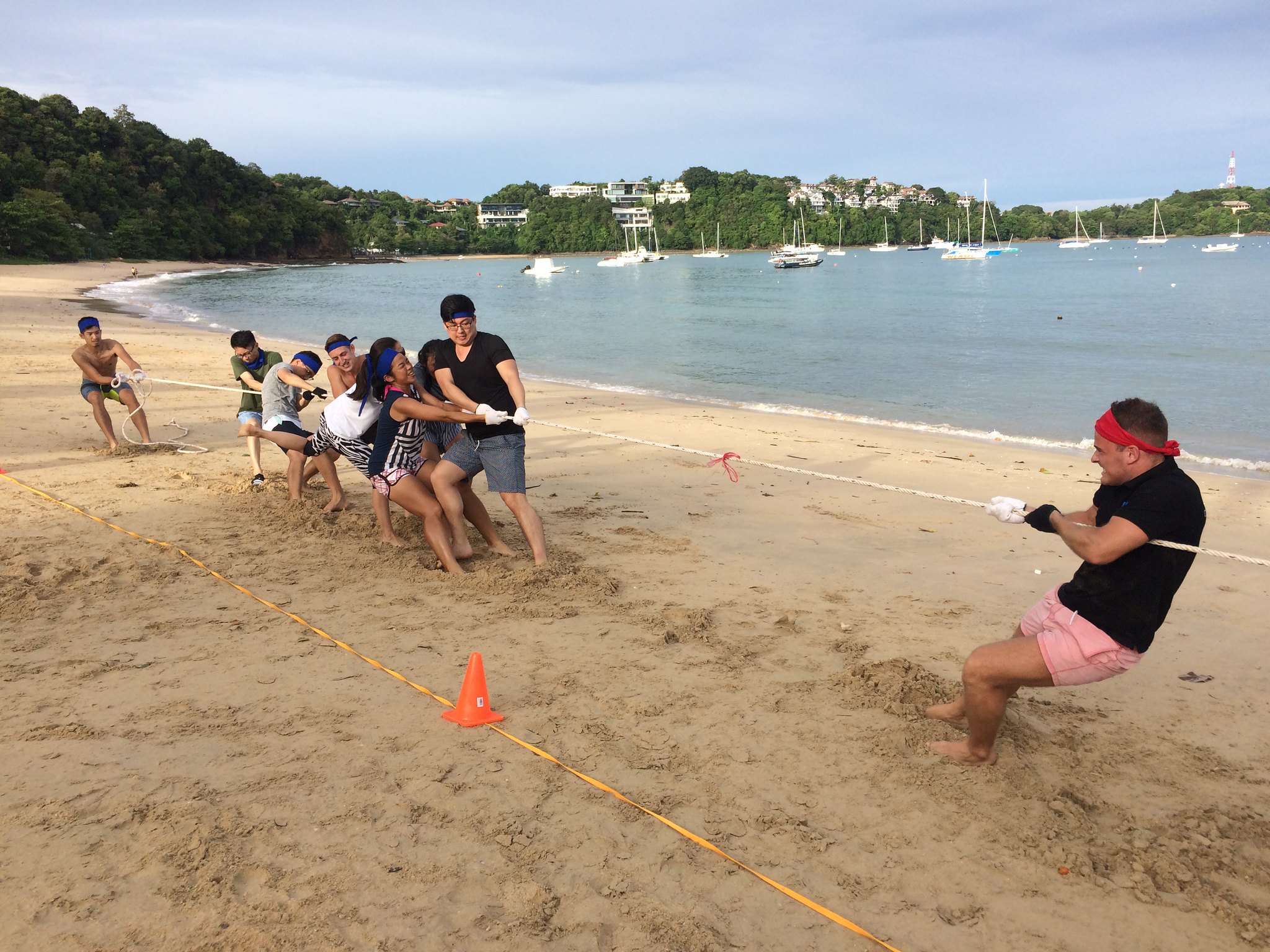Energy, Resilience, and Outdoor Engagement Corporate team participating in an outdoor beach challenge that builds resilience, energy, and team engagement