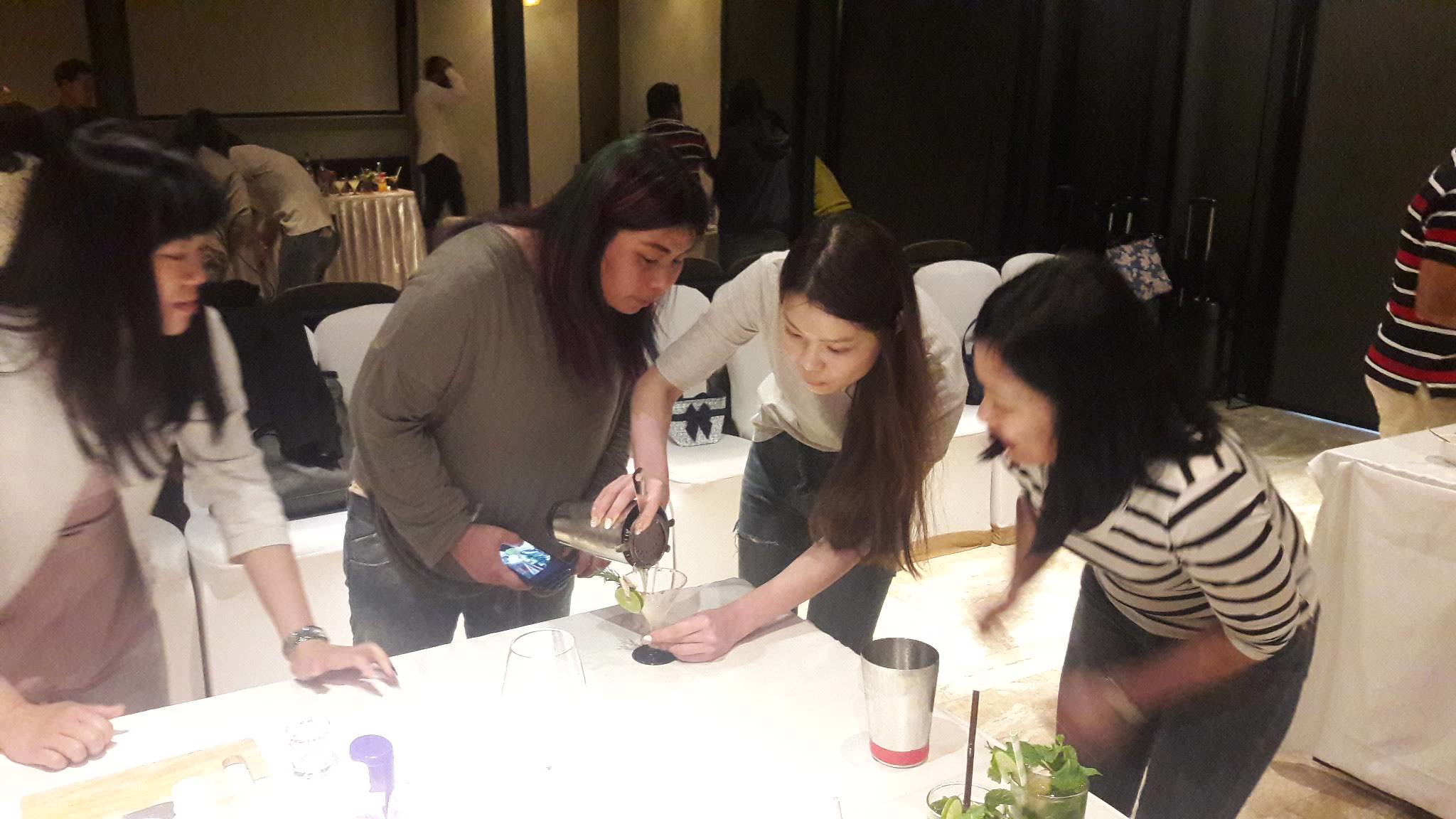 Friendly Competition and Presentation Confidence Team members preparing cocktails during a friendly competition that builds presentation confidence and collaboration