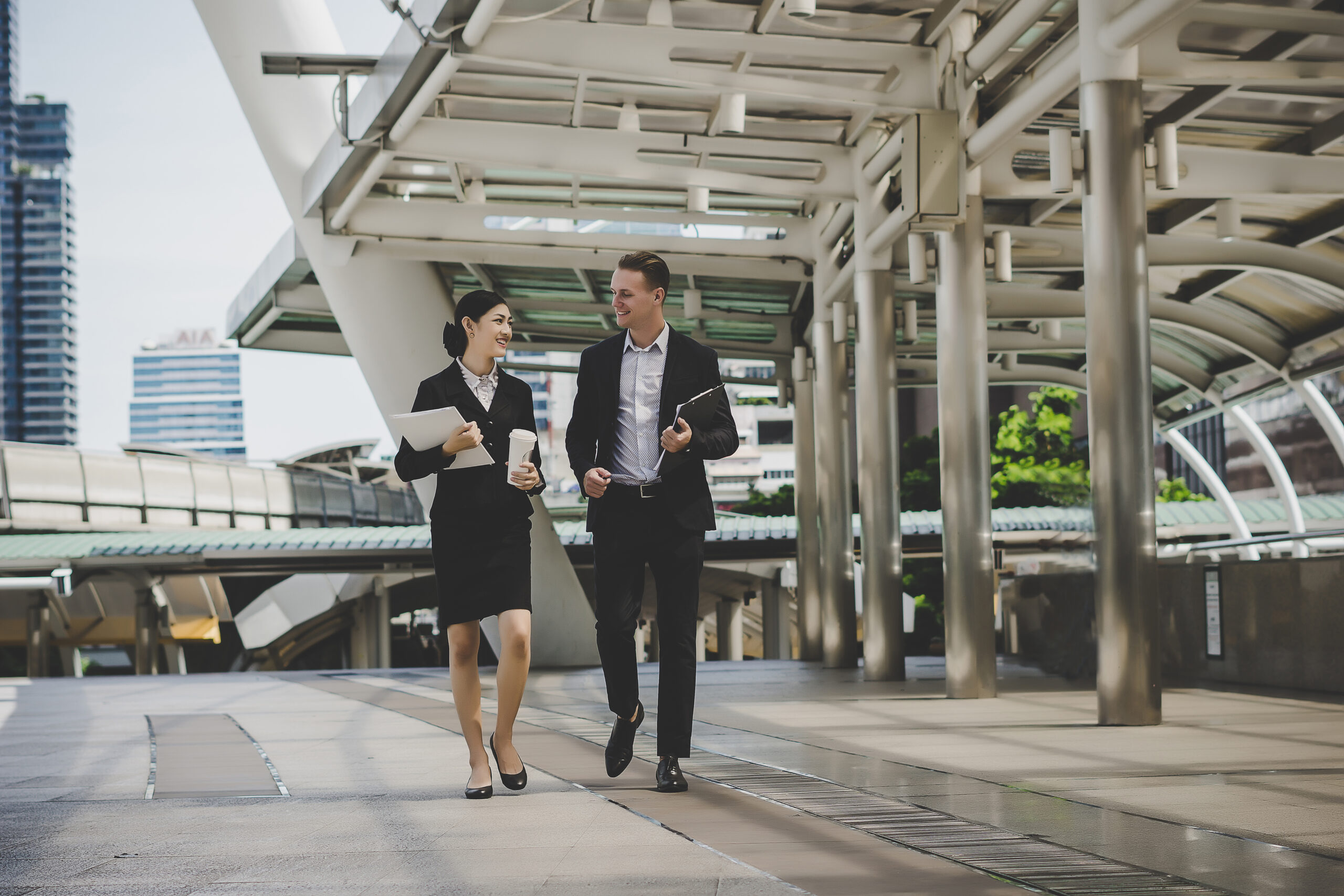 Colleague talking together while coming back from work. Event managers coordinating guest flow, registration, and on-site exhibition operations in Bangkok