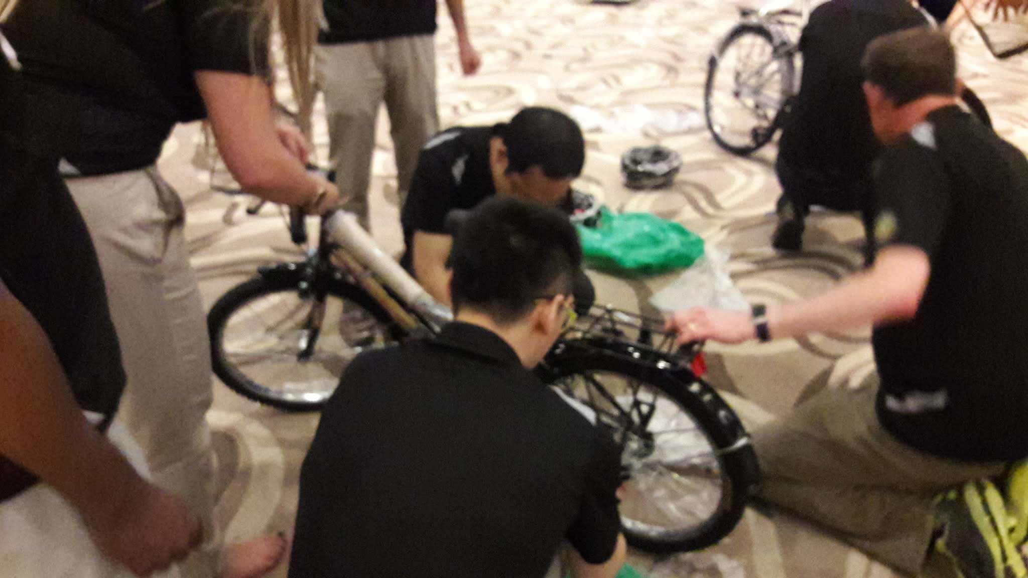 Role Coordination Reveals Different Team Strengths Corporate colleagues coordinating roles during a bike assembly team-building activity in Bangkok to strengthen collaboration and teamwork
